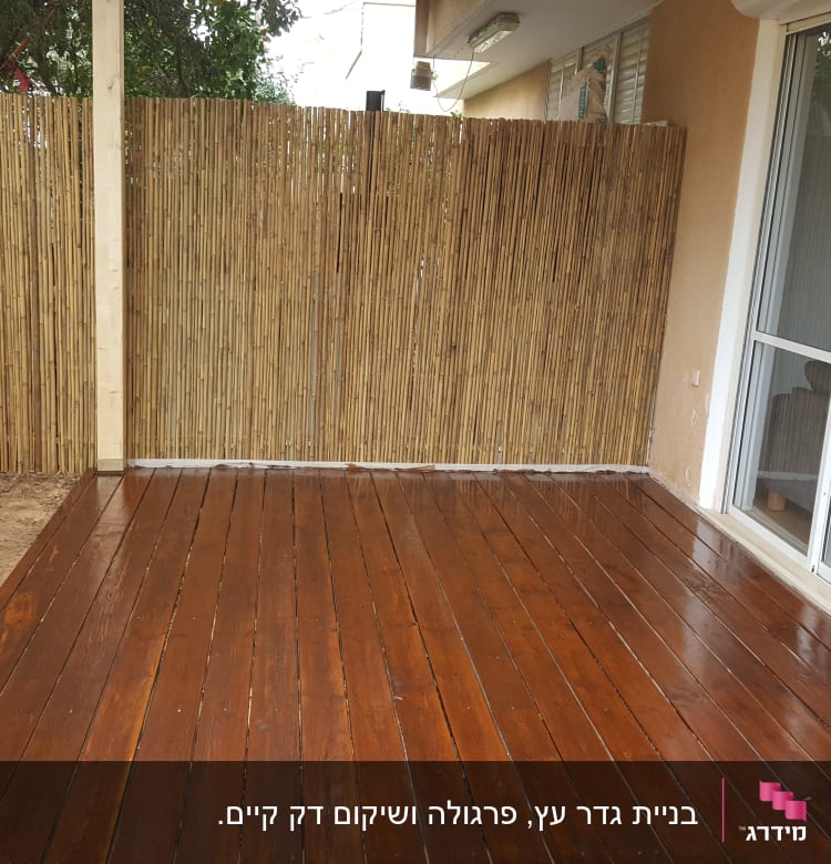 רצפת עץ עם גדר במבוק בחצר